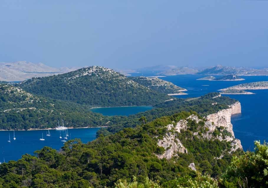 The white cliffs of Telašćica, sailboats at anchor beneath the estate's protected coastline.